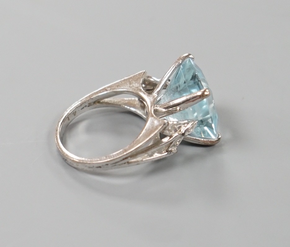 A white metal and single stone square cut aquamarine set dress ring, with diamond set shoulders, size K, gross weight 7 grams.